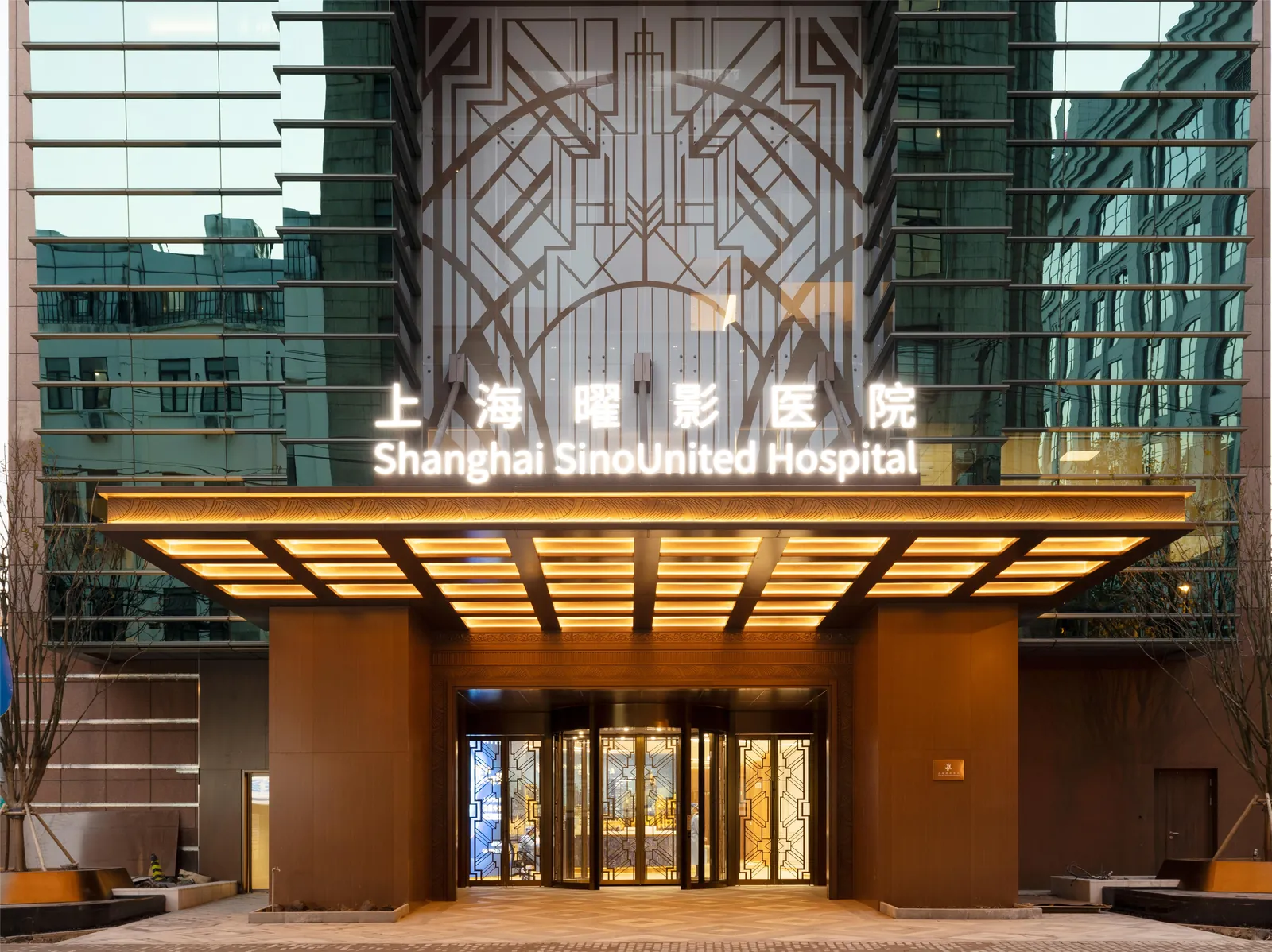 The lit entrance canopy of Shanghai SinoUnited Hospital at dusk
