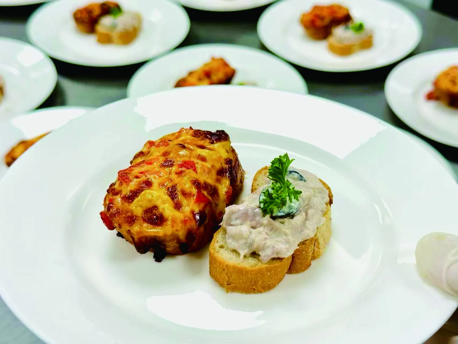 Plated hot canapés with cheese gratin and pâté crostini