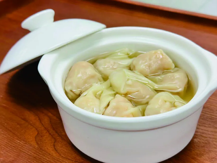 Wonton soup served in a covered ceramic pot