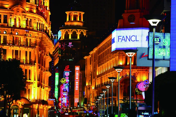 Neon-lit shopfronts along Nanjing Road at night