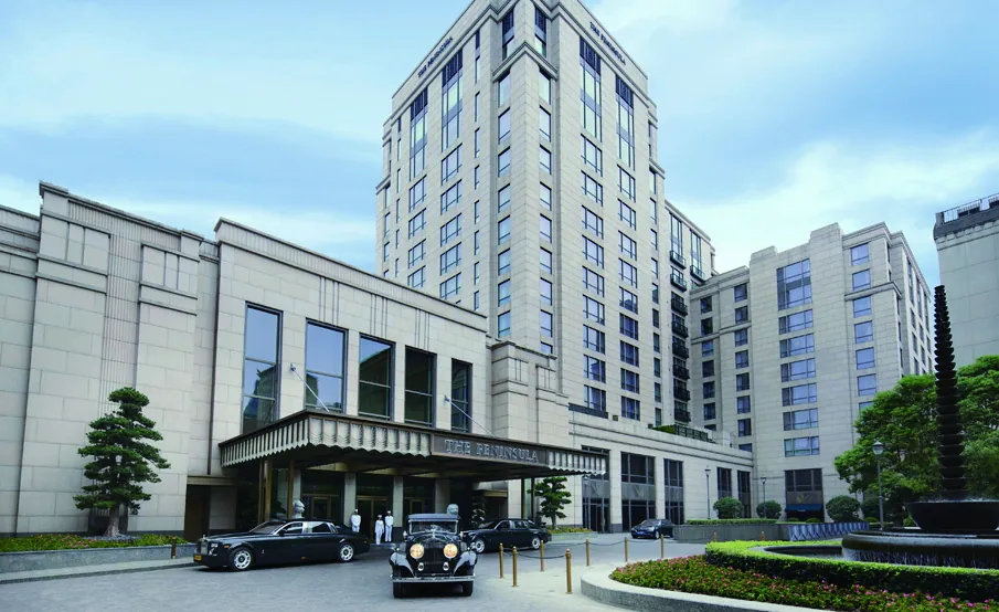 The entrance of an international five-star hotel near the hospital, with cars at the porte-cochère