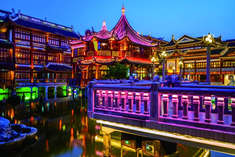 Traditional pavilions of Yu Garden reflected in water at night