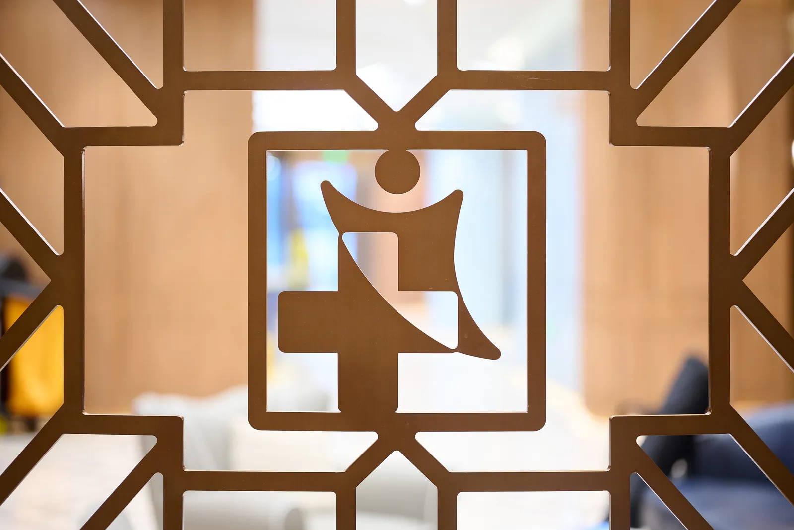 The SinoUnited Health mark cut into a bronze screen in the hospital interior