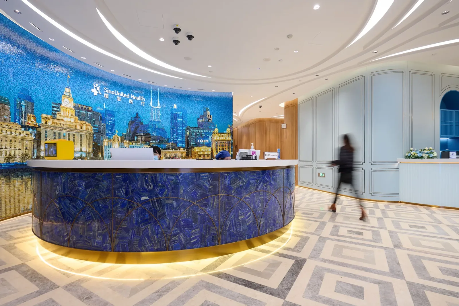 Reception at Shanghai SinoUnited Hospital, with a mosaic of the Bund skyline behind the desk